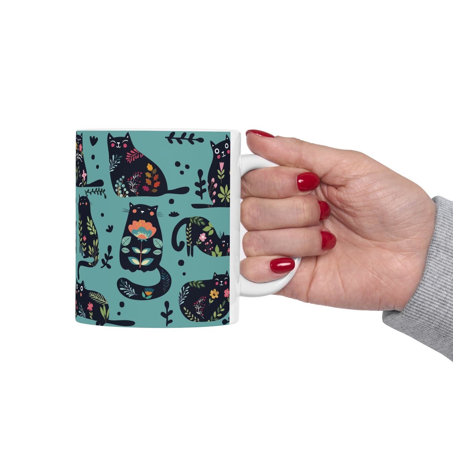 Mug with black cats and floral pattern on a blue background.