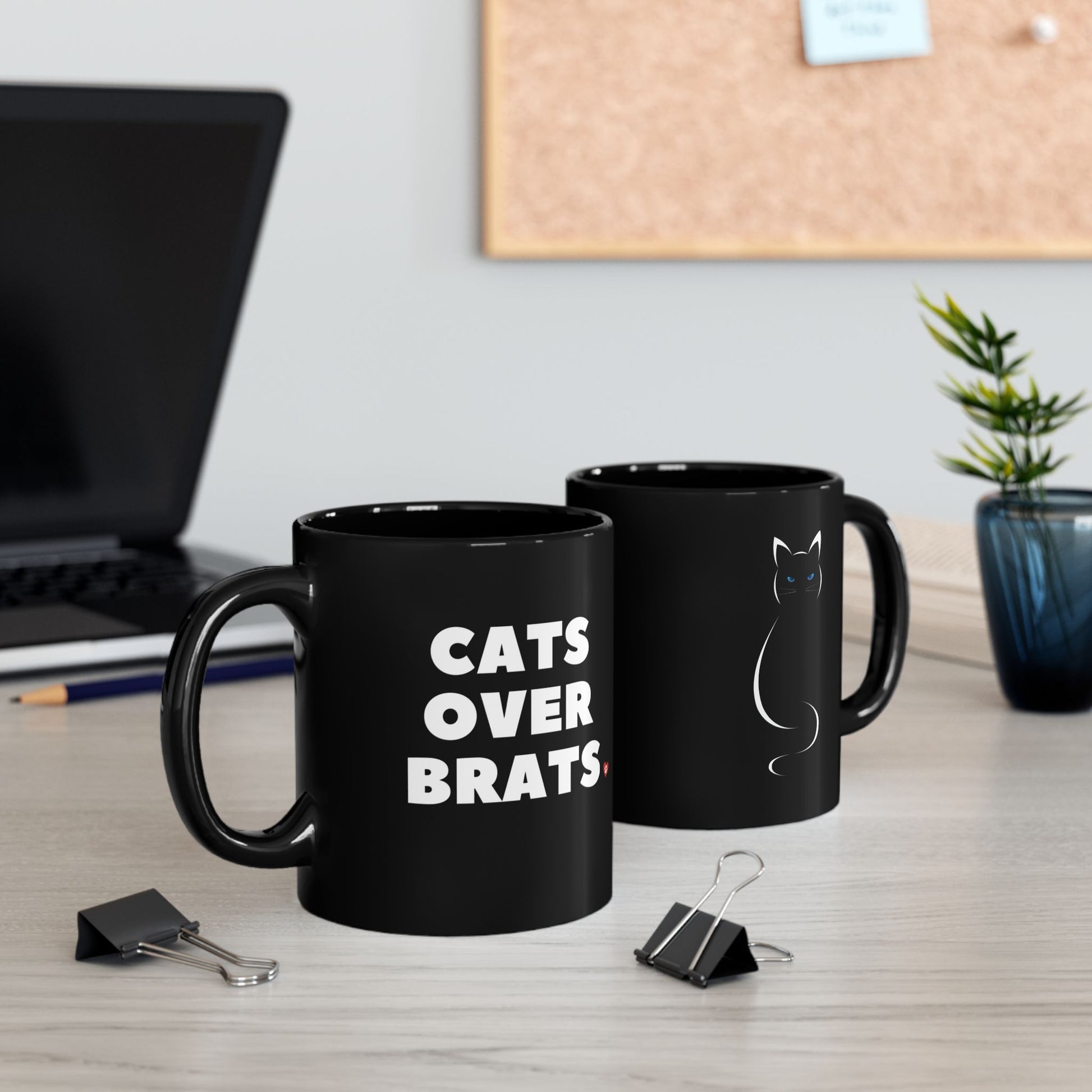 Black mug with 'CATS OVER BRATS' text and cat graphic.
