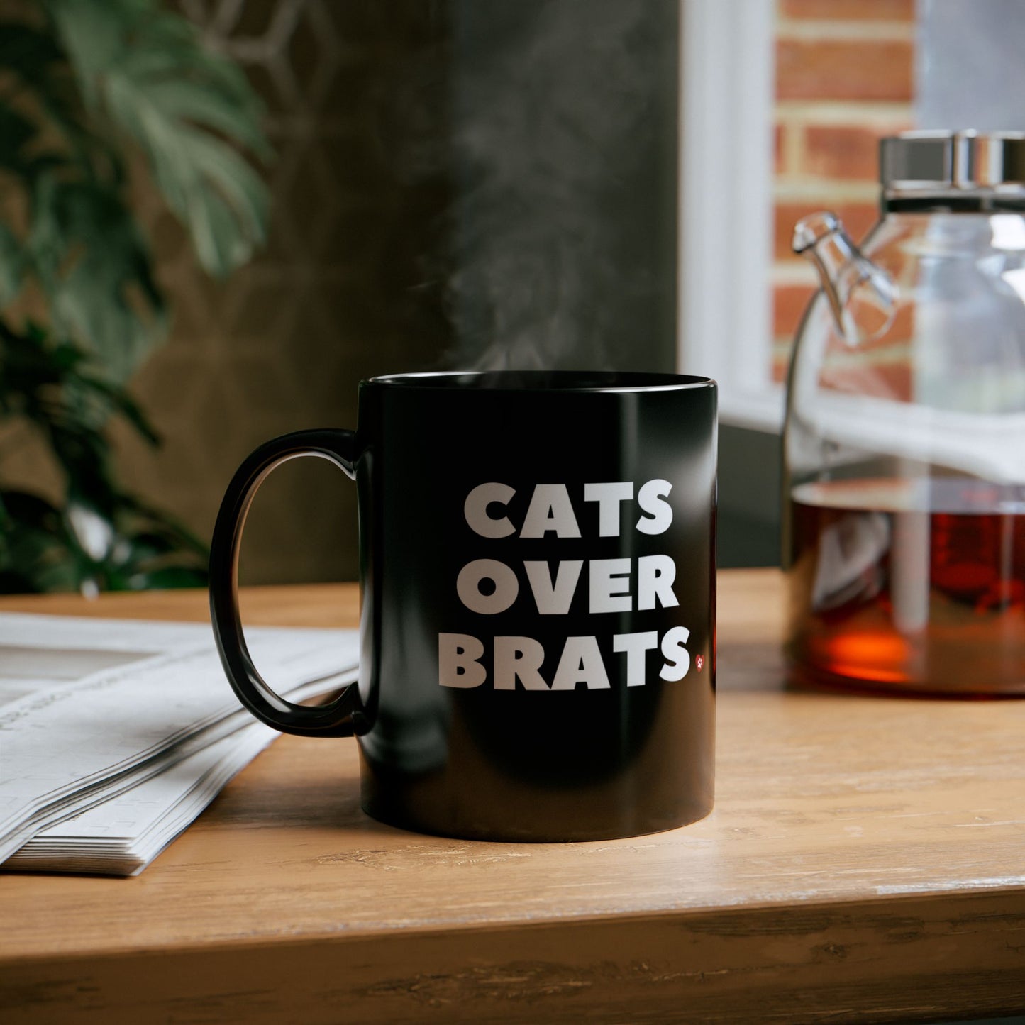 Black mug with 'CATS OVER BRATS' text and cat graphic.
