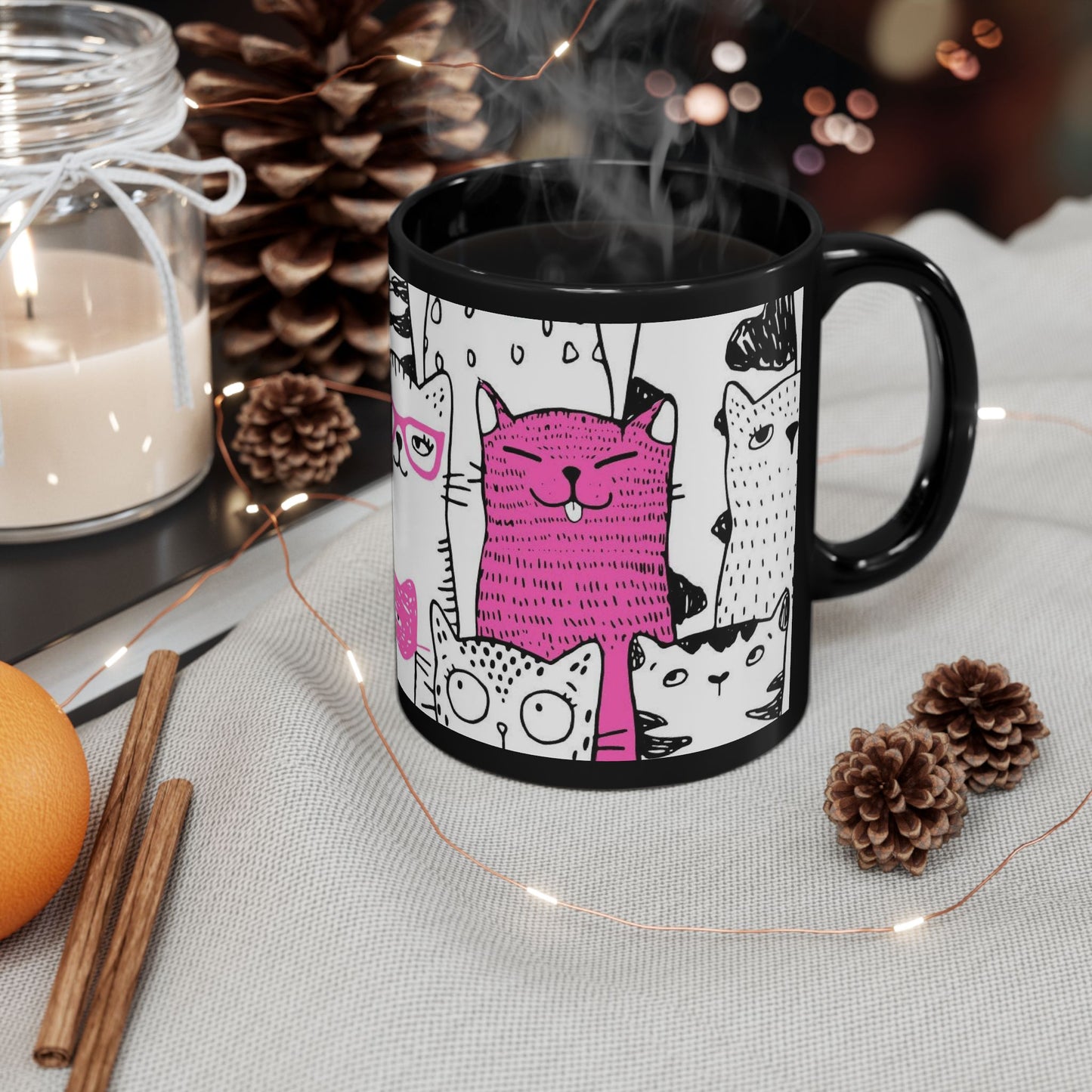 Black mug with cartoon cat illustrations.