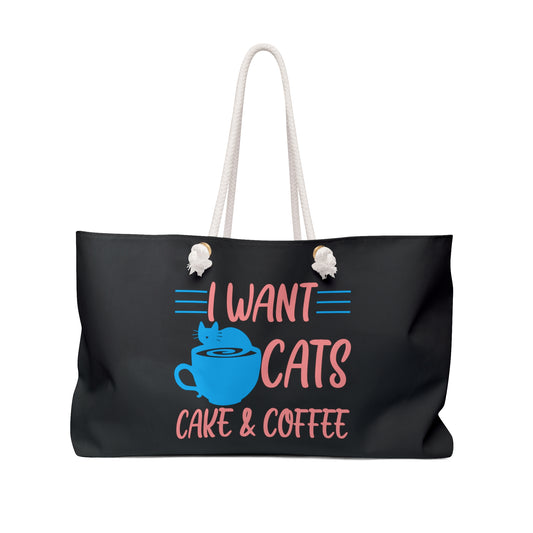 Black weekender tote bag with 'I Want Cats, Cake & Coffee' text and a blue cat on a coffee cup graphic  