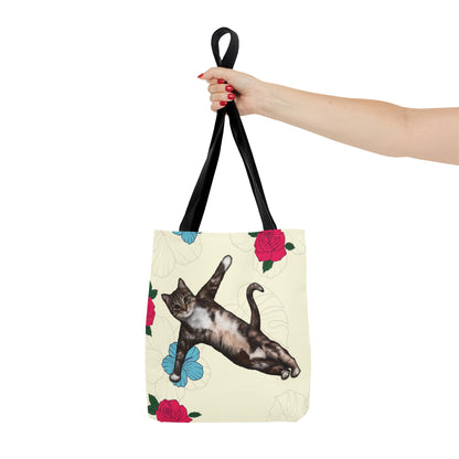 Tote bag with a cat in a yoga pose illustration against floral design on a cream background