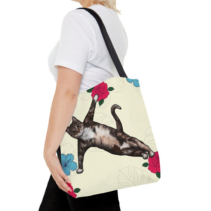 Tote bag with a cat in a yoga pose illustration against floral design on a cream background