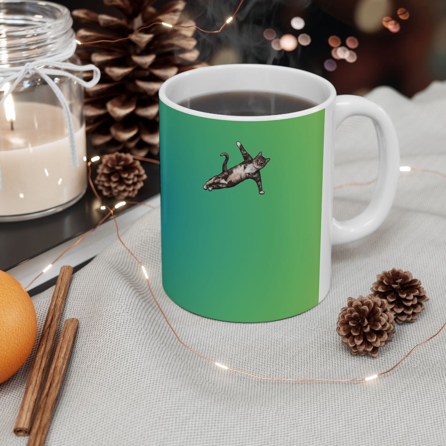 Green mug and graphic of a cat in a yoga pose.
