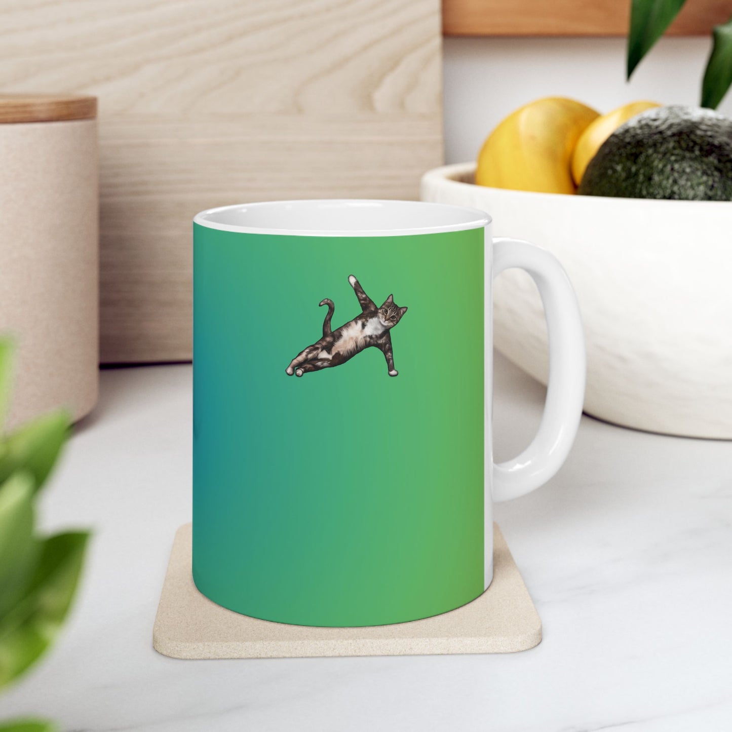 Green mug and graphic of a cat in a yoga pose.