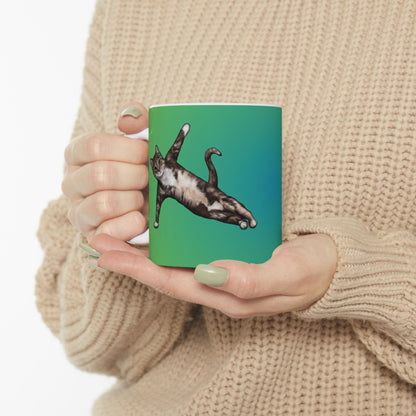 Green mug and graphic of a cat in a yoga pose.