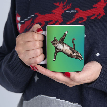 Green mug and graphic of a cat in a yoga pose.