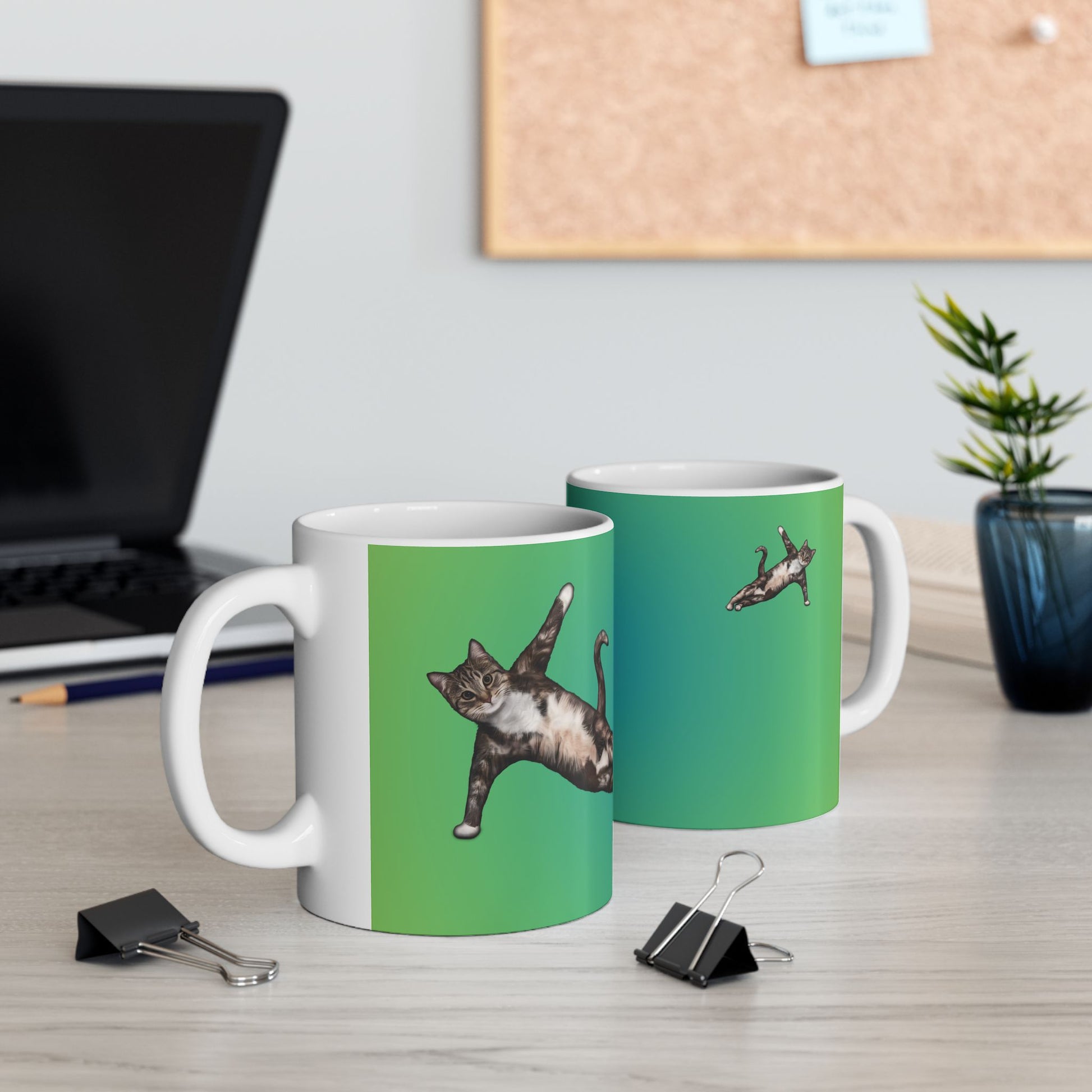 Green mug and graphic of a cat in a yoga pose.