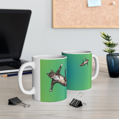 Green mug and graphic of a cat in a yoga pose.