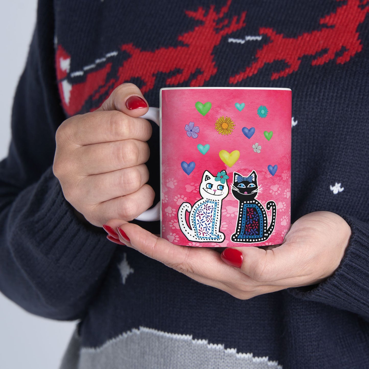 Mug with two cats and colorful hearts and flowers design on a pink background.
