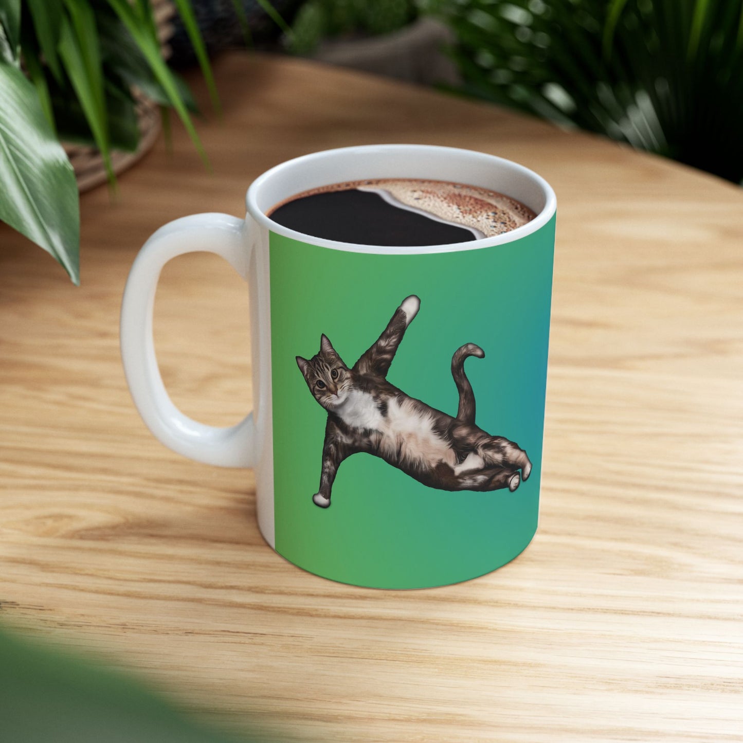 Green mug and graphic of a cat in a yoga pose.