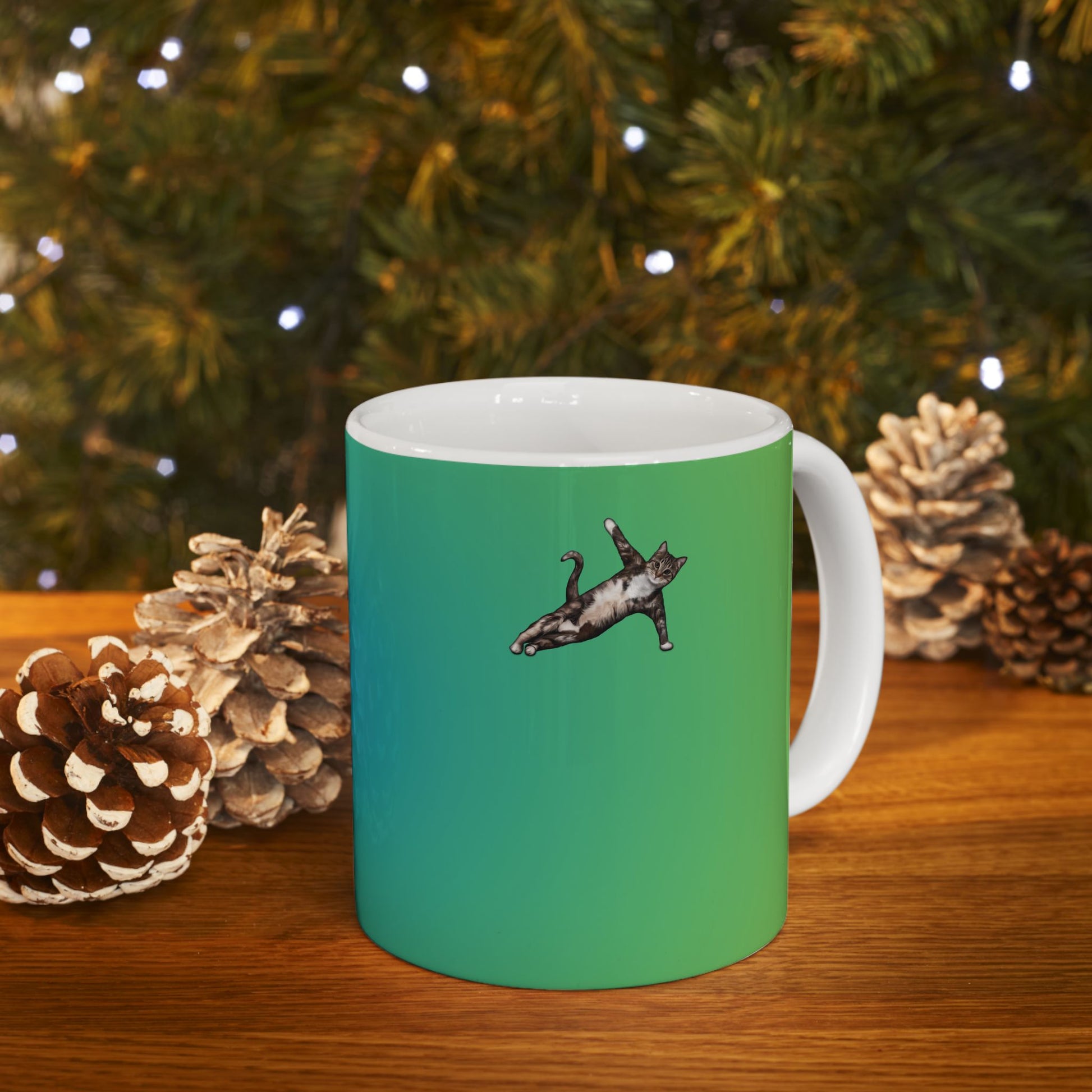 Green mug and graphic of a cat in a yoga pose.