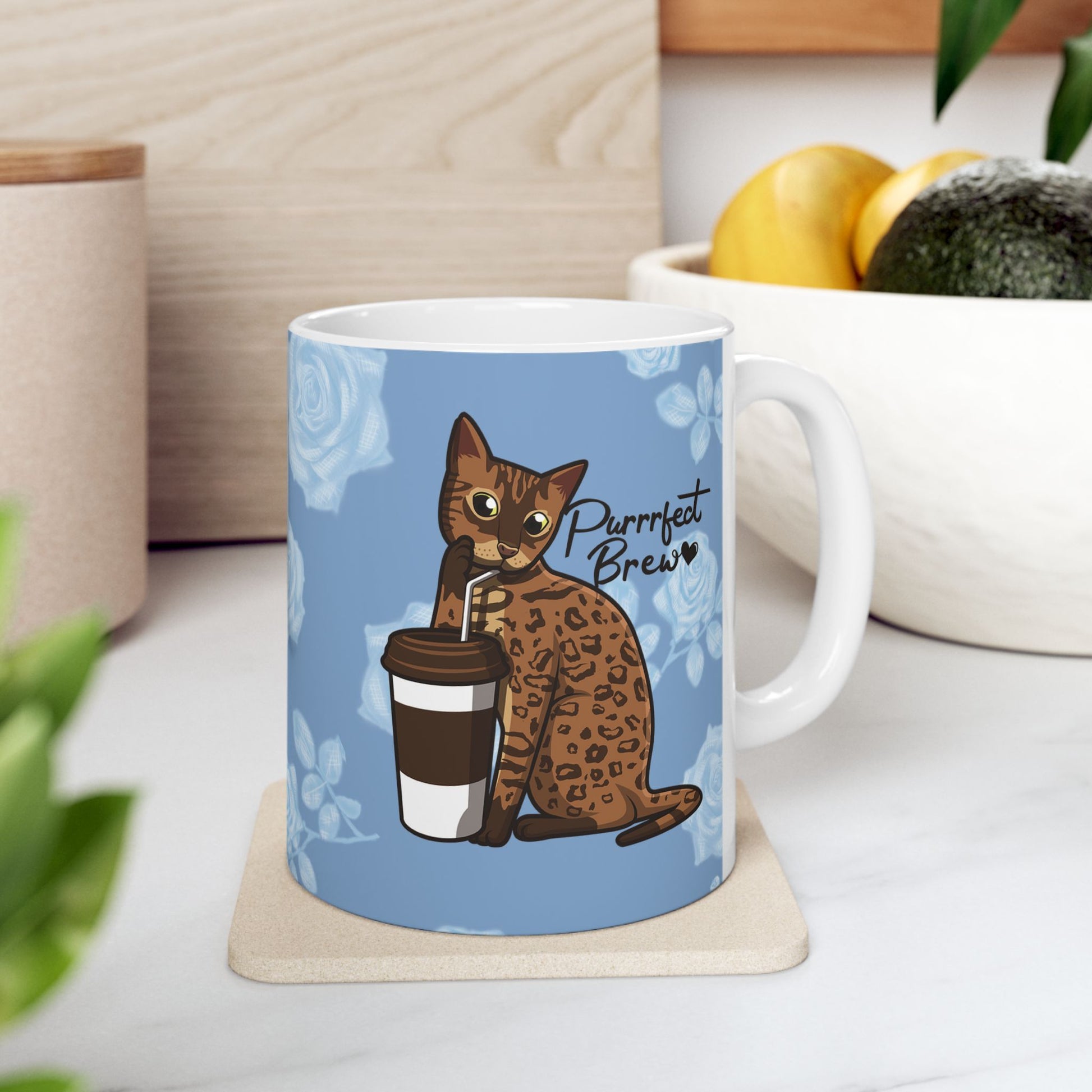 Mug with a Bengal cat drinking from a coffee cup and 'Purrrfect Brew' text on a blue floral patterned background.