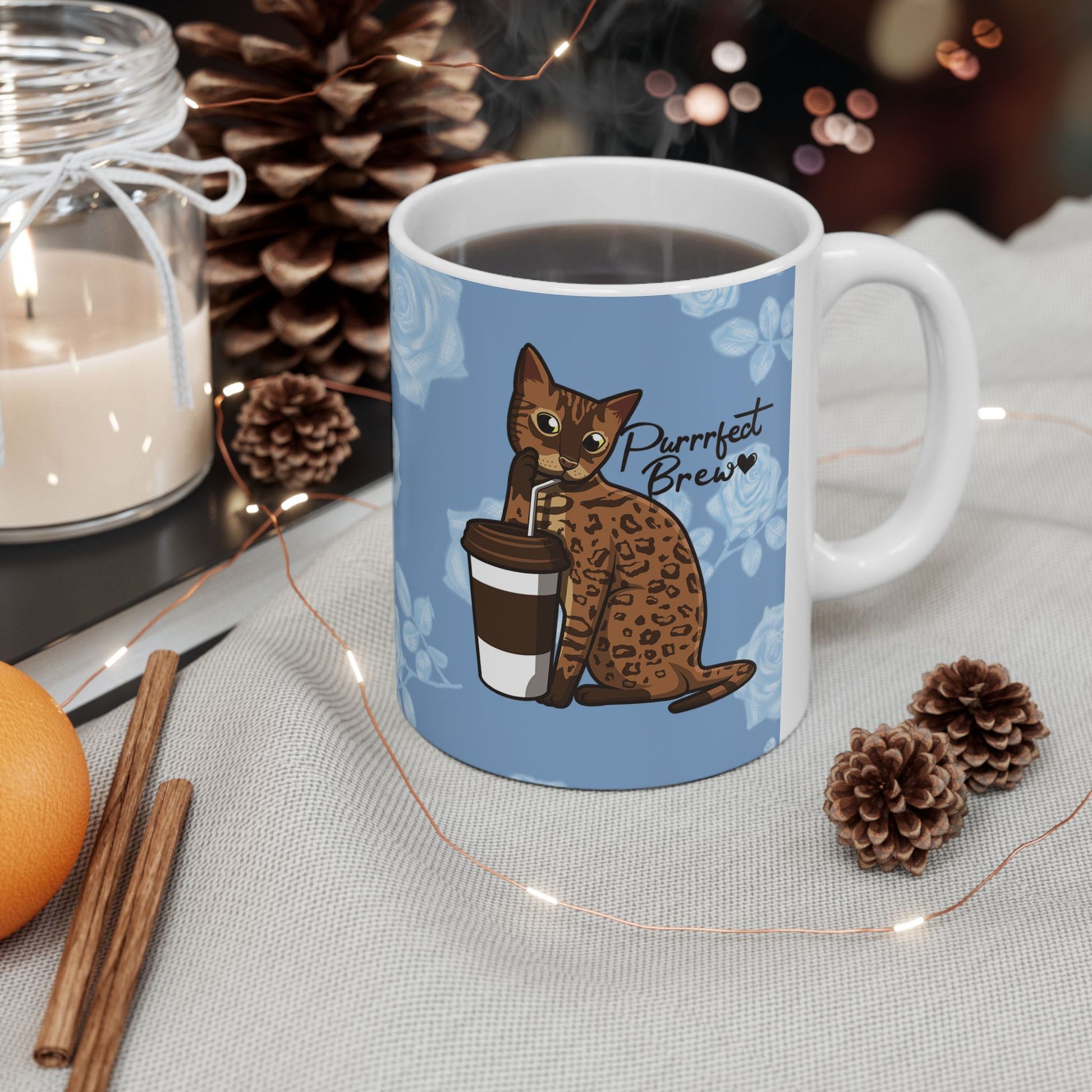 Mug with a Bengal cat drinking from a coffee cup and 'Purrrfect Brew' text on a blue floral patterned background.