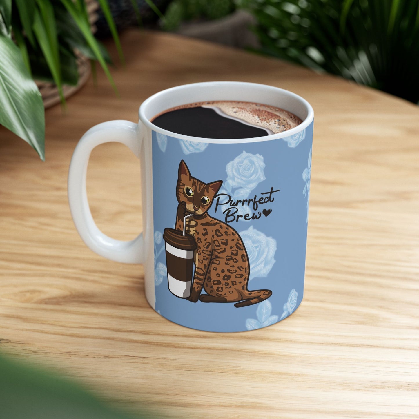Mug with a Bengal cat drinking from a coffee cup and 'Purrrfect Brew' text on a blue floral patterned background.