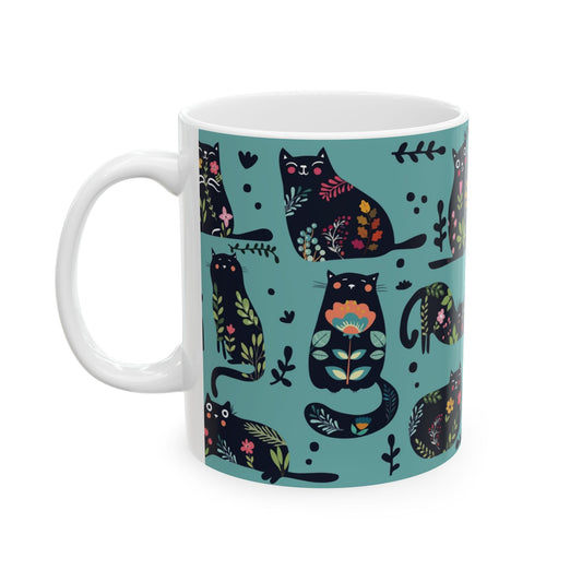 Mug with black cats and floral pattern on a blue background.