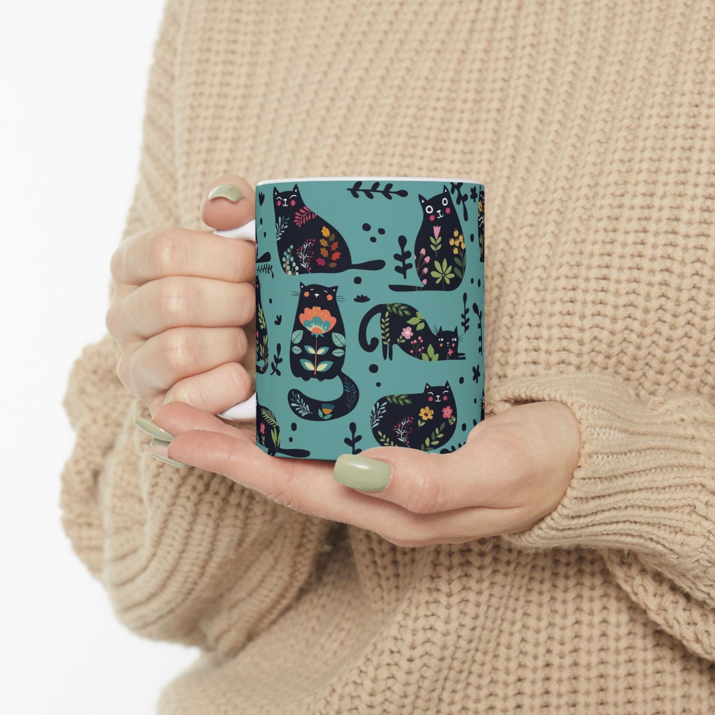Mug with black cats and floral pattern on a blue background.