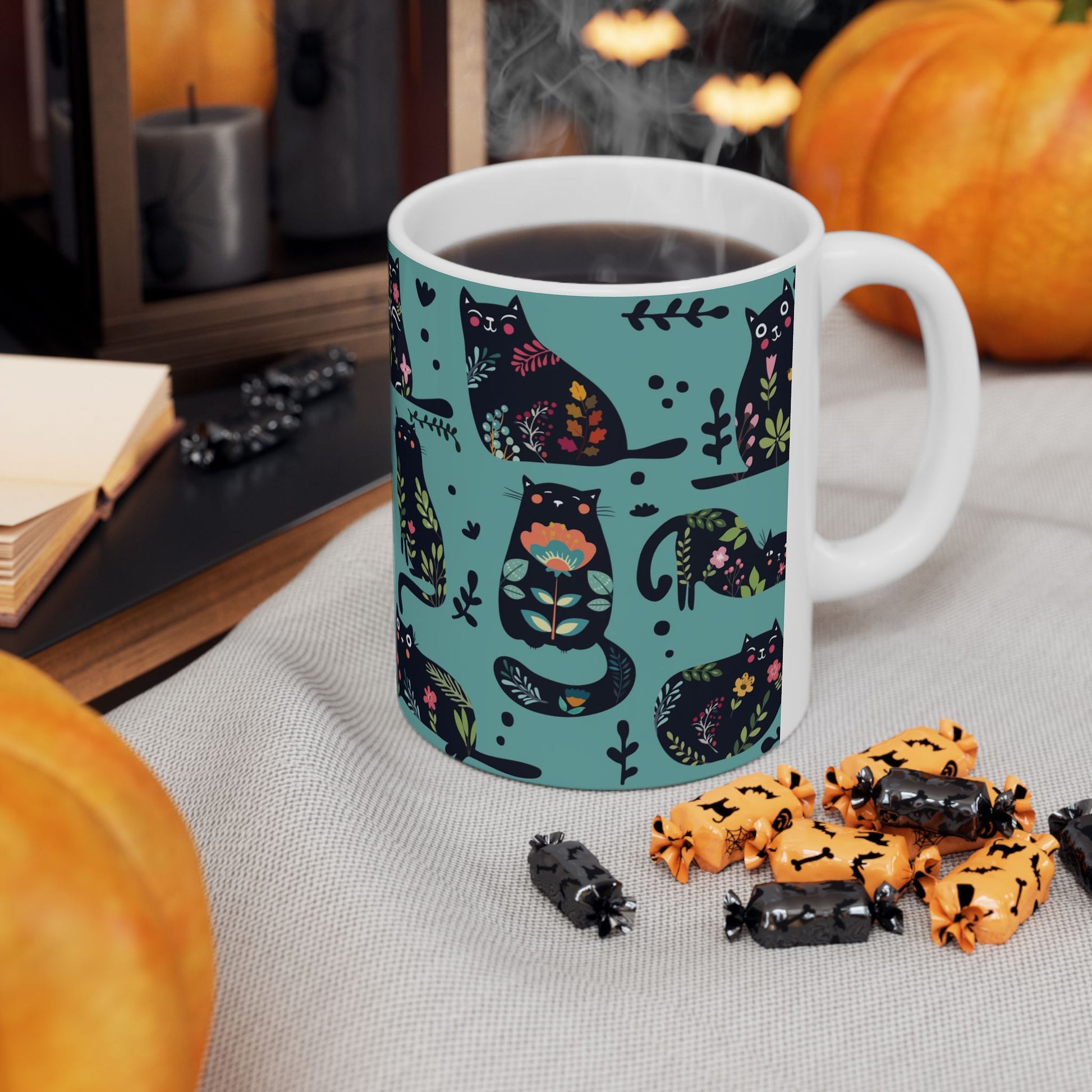 Mug with black cats and floral pattern on a blue background.