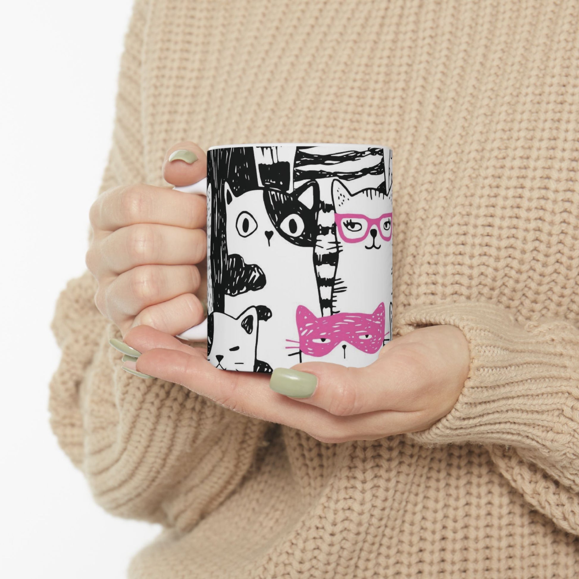 White mug with cartoon black and white cat illustrations.