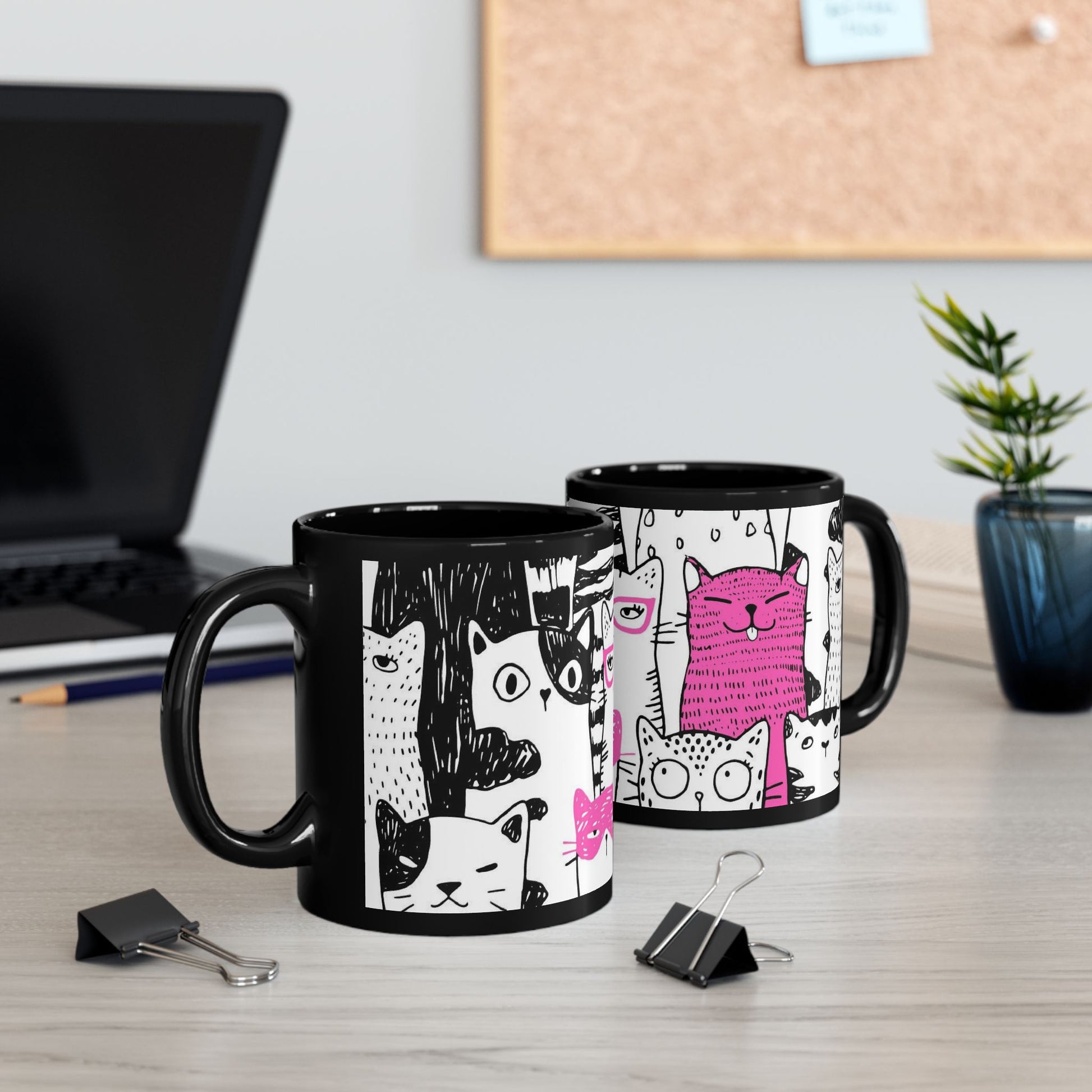 Black mug with cartoon cat illustrations.