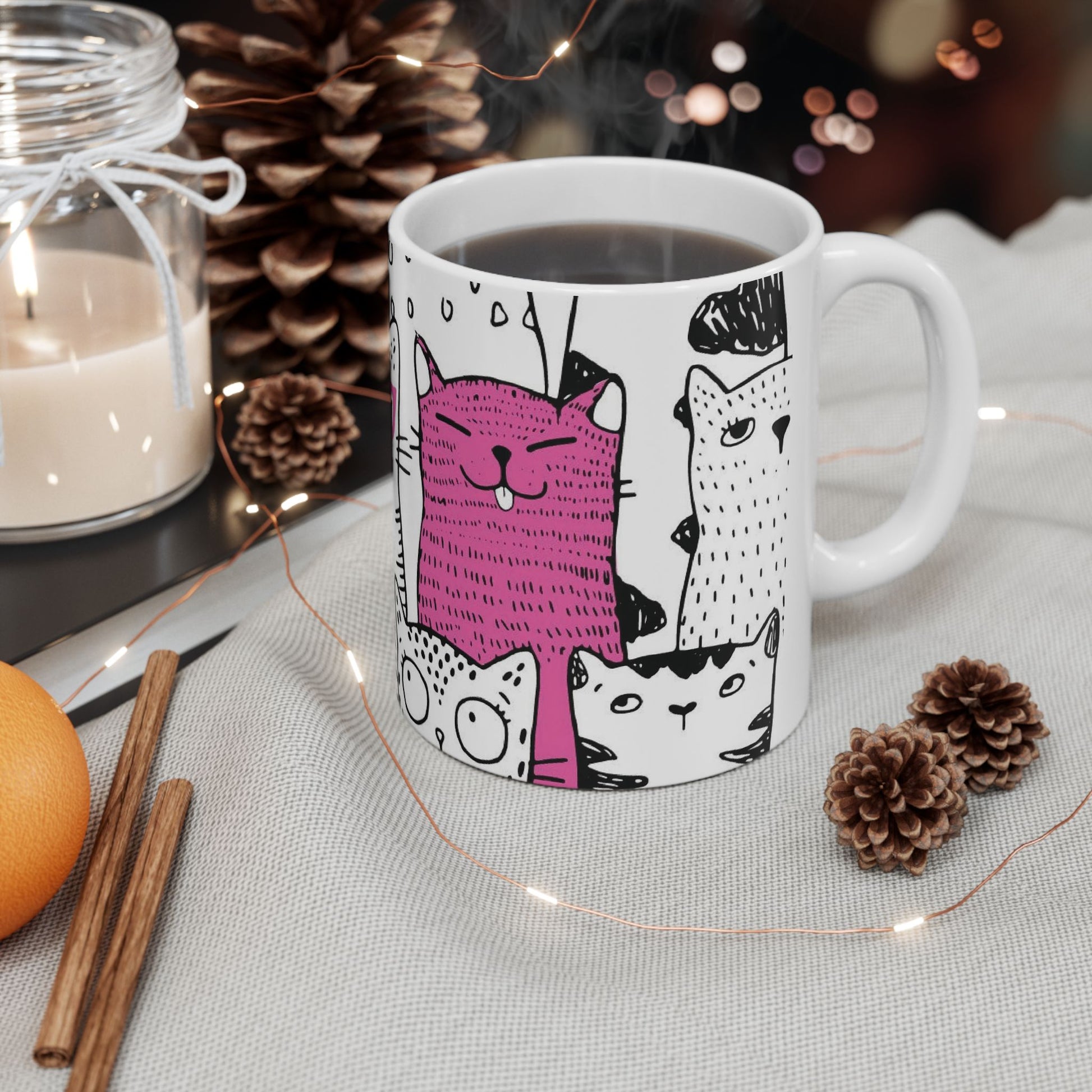 White mug with cartoon black and white cat illustrations.