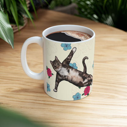 Mug with a cat in a yoga pose on a floral background.