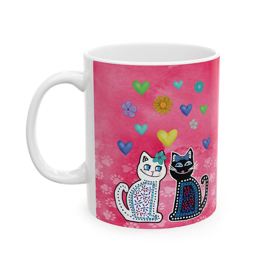 Mug with two cats and colorful hearts and flowers design on a pink background.