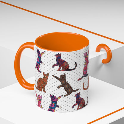 Orange mug with colorful cat silhouette pattern.