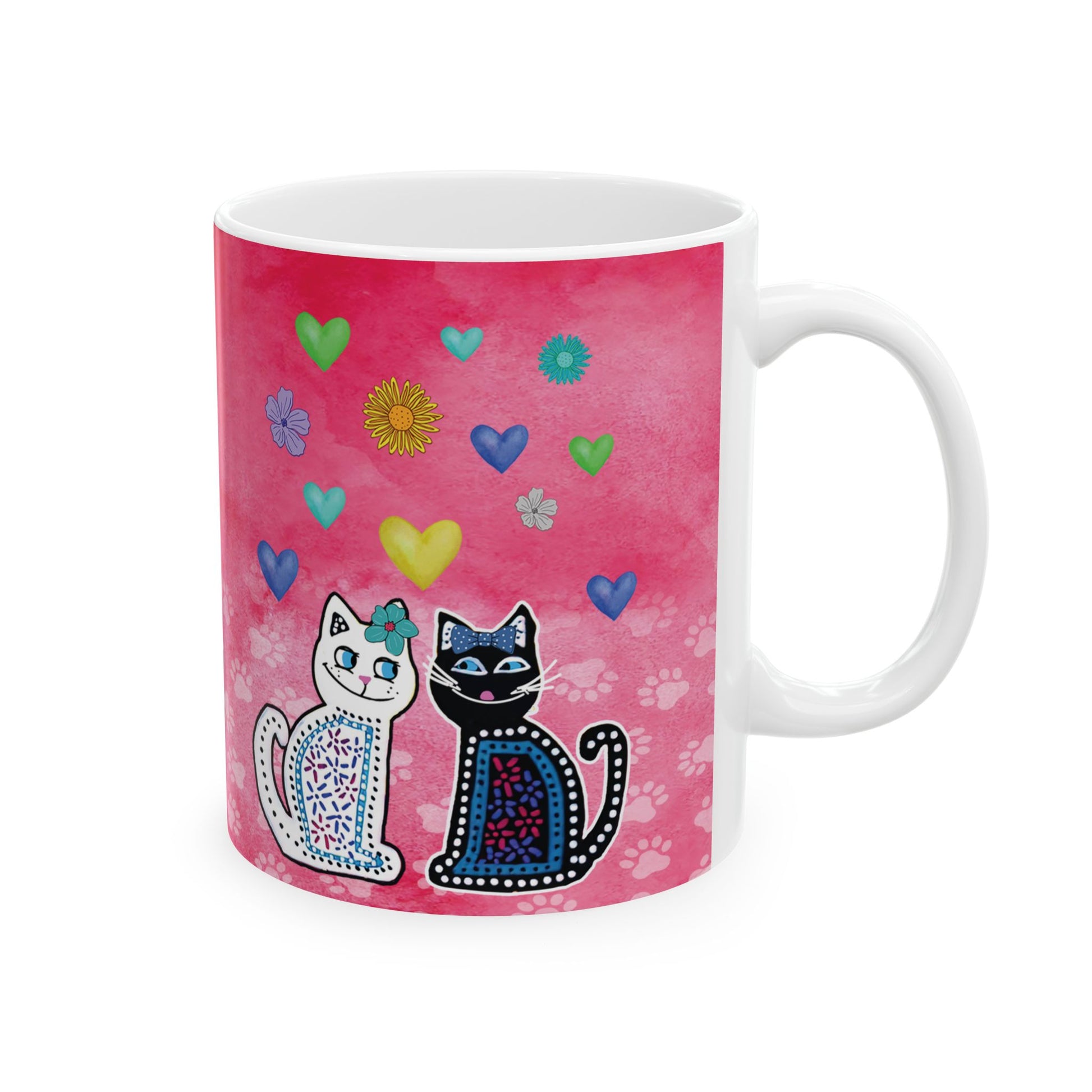 Mug with two cats and colorful hearts and flowers design on a pink background.