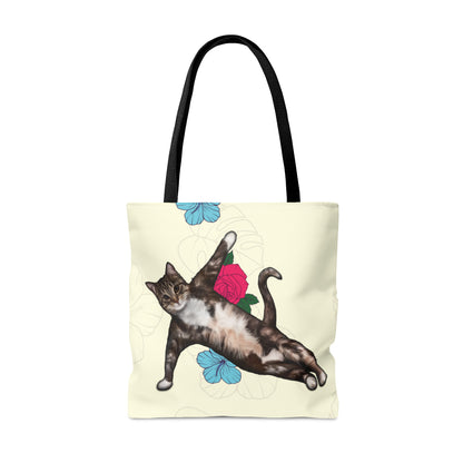 Tote bag with a cat in a yoga pose illustration against floral design on a cream background