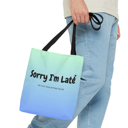 Tote bag with the text "Sorry I'm Late My Cat Was Sitting On Me" and black and white cat illustrations. 
