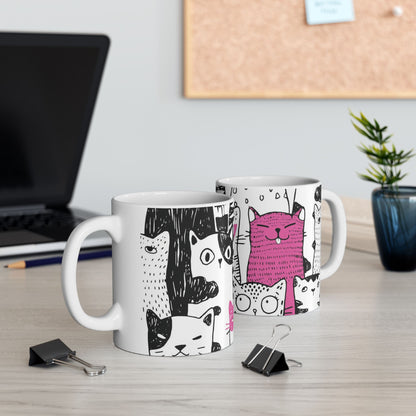 White mug with cartoon black and white cat illustrations.