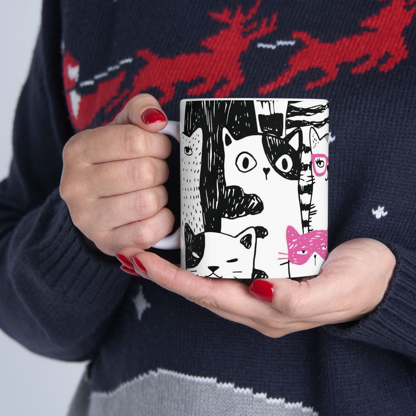 White mug with cartoon black and white cat illustrations.