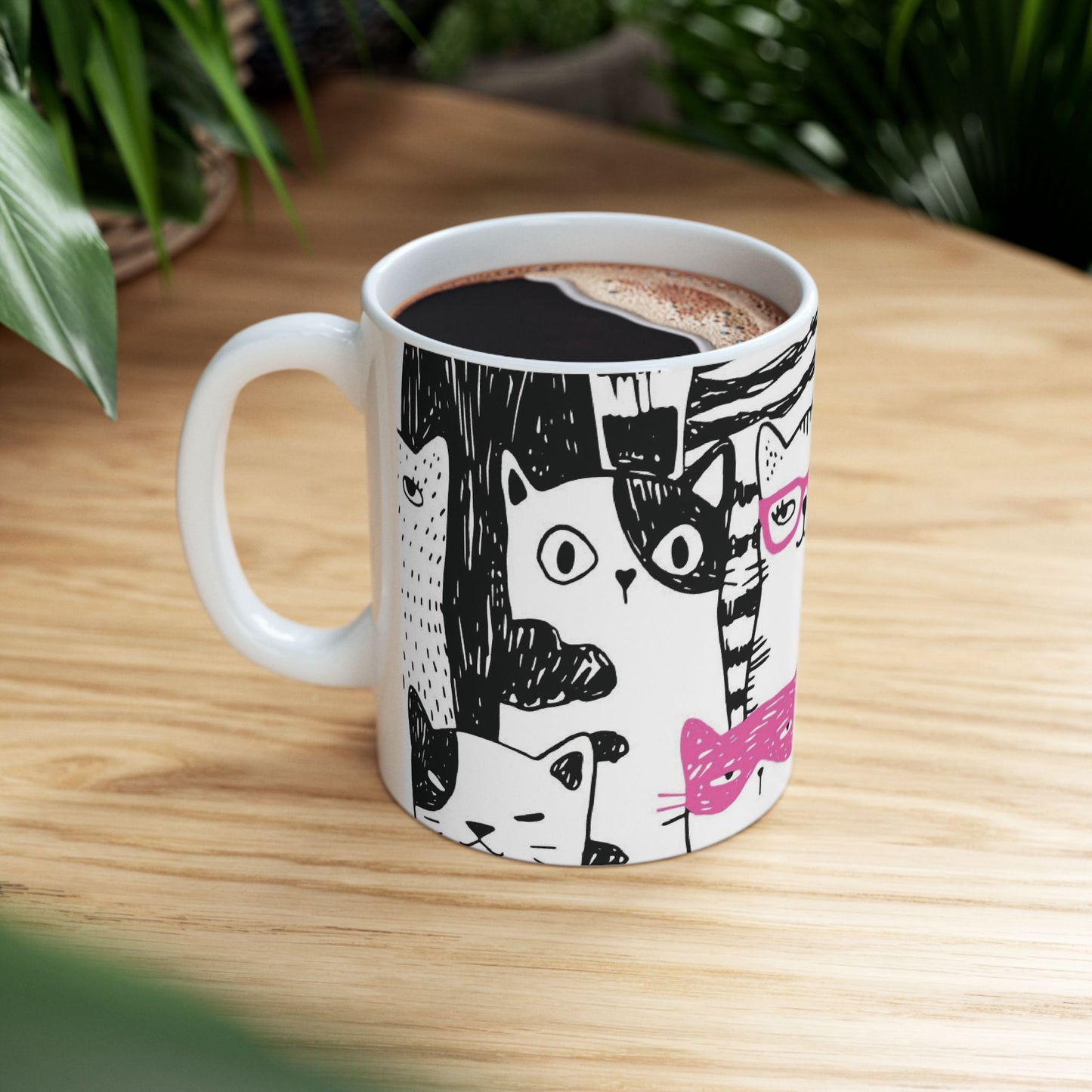 White mug with cartoon black and white cat illustrations.