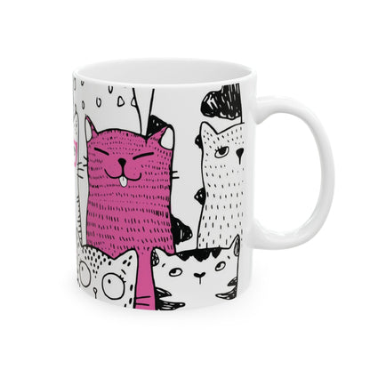 White mug with cartoon black and white cat illustrations.