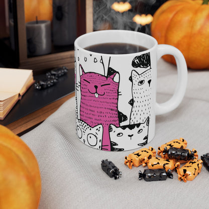 White mug with cartoon black and white cat illustrations.