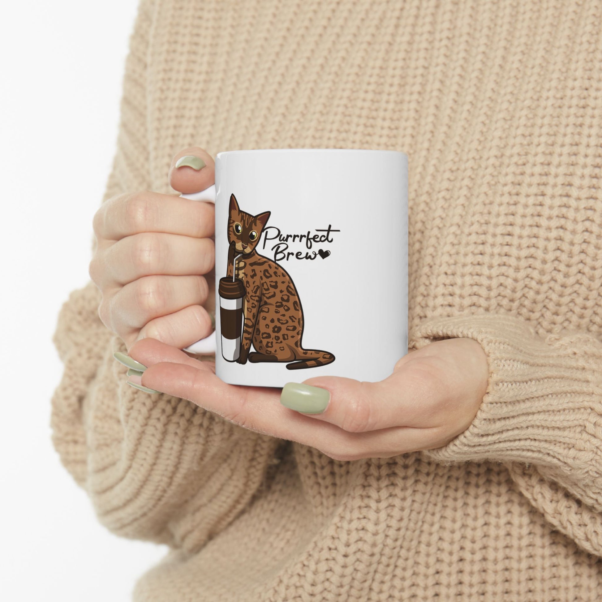 White mug with illustration of a Bengal Cat posing with a coffee cup and text 'Purrrfect Brew.'  