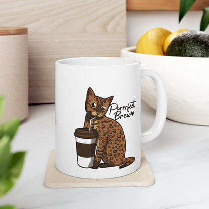White mug with illustration of a Bengal Cat posing with a coffee cup and text 'Purfect Brew'  