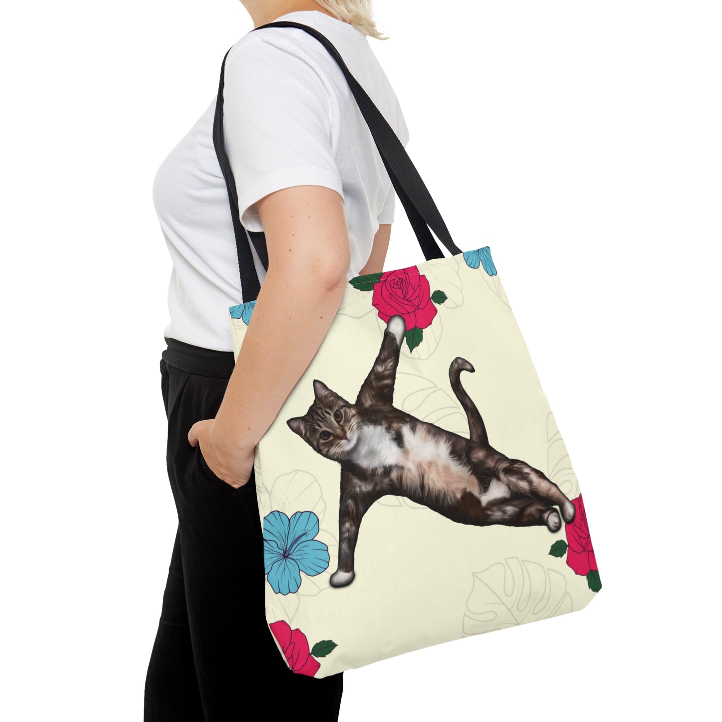 Tote bag with a cat in a yoga pose illustration against floral design on a cream background