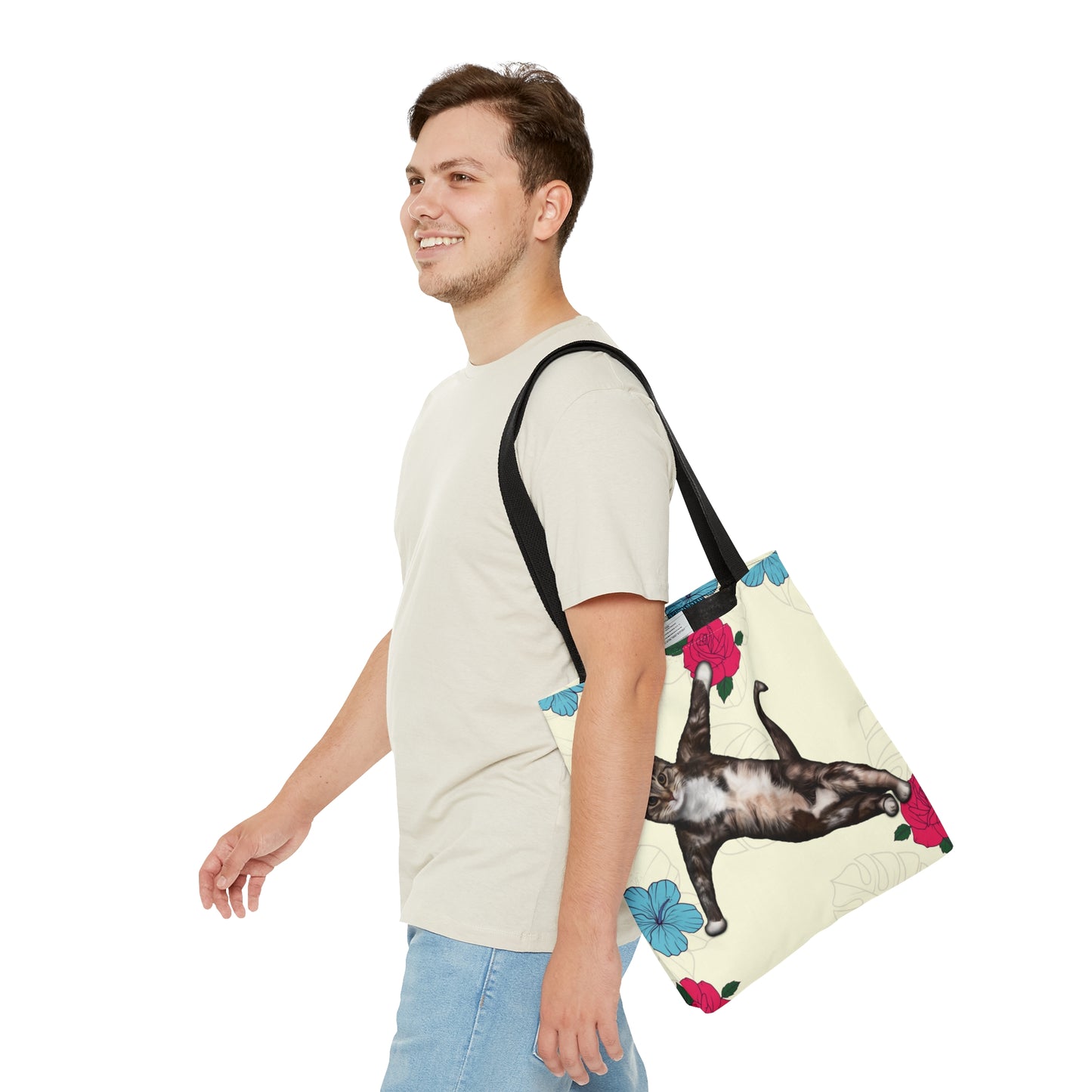 Tote bag with a cat in a yoga pose illustration against floral design on a cream background
