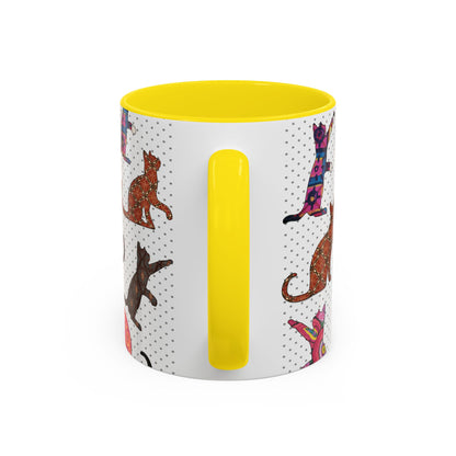 Yellow mug with colorful cat silhouette pattern.