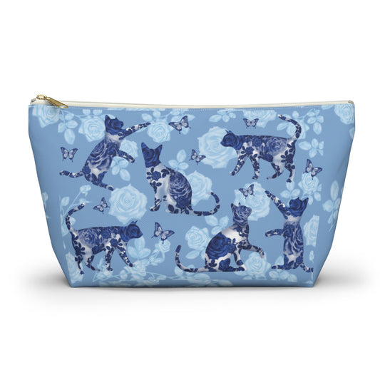 A floral blue accessory bag with a pattern of kitty silhouettes, roses, and butterflies, featuring a zipper closure. Cosmetic, makeup, toiletry, travel, pencil case & everyday essentials bag for cat lovers.
