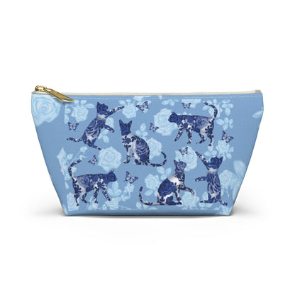 A floral blue accessory bag with a pattern of kitty silhouettes, roses, and butterflies, featuring a zipper closure. Cosmetic, makeup, toiletry, travel, pencil case & everyday essentials bag for cat lovers.