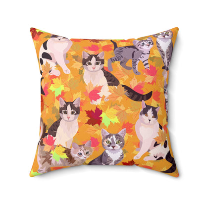 A square-shaped throw pillow with a fall leaves pattern, featuring various cartoon cats among the leaves.